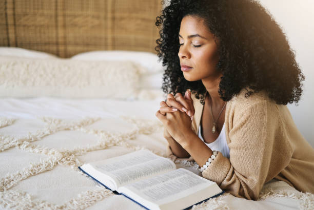 Woman praying with an open Bible